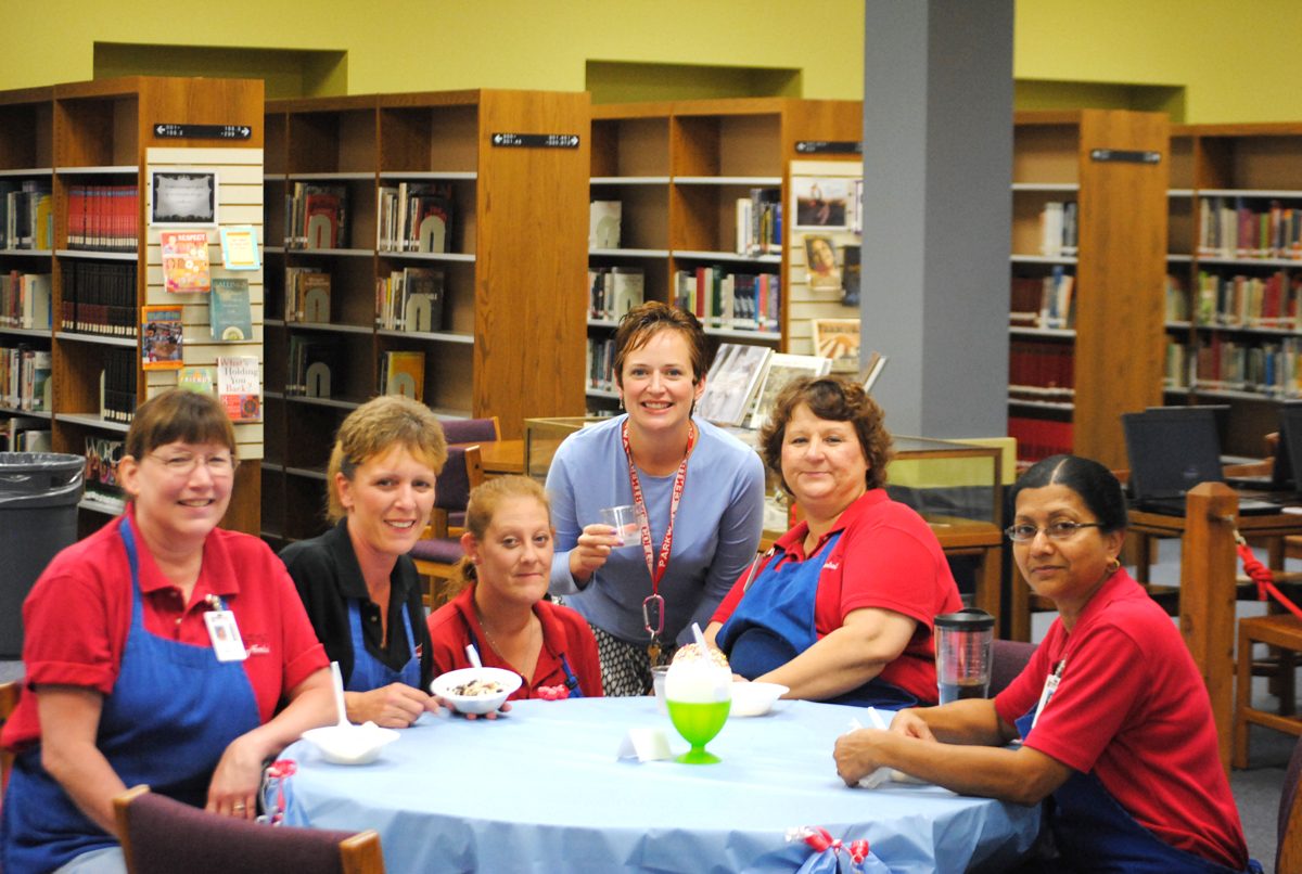 The lunch ladies and Mrs. Brigid Dolan (center) enjoy their frozen treats at the staff ice cream social in the library. Photo by Brandon Weissman.