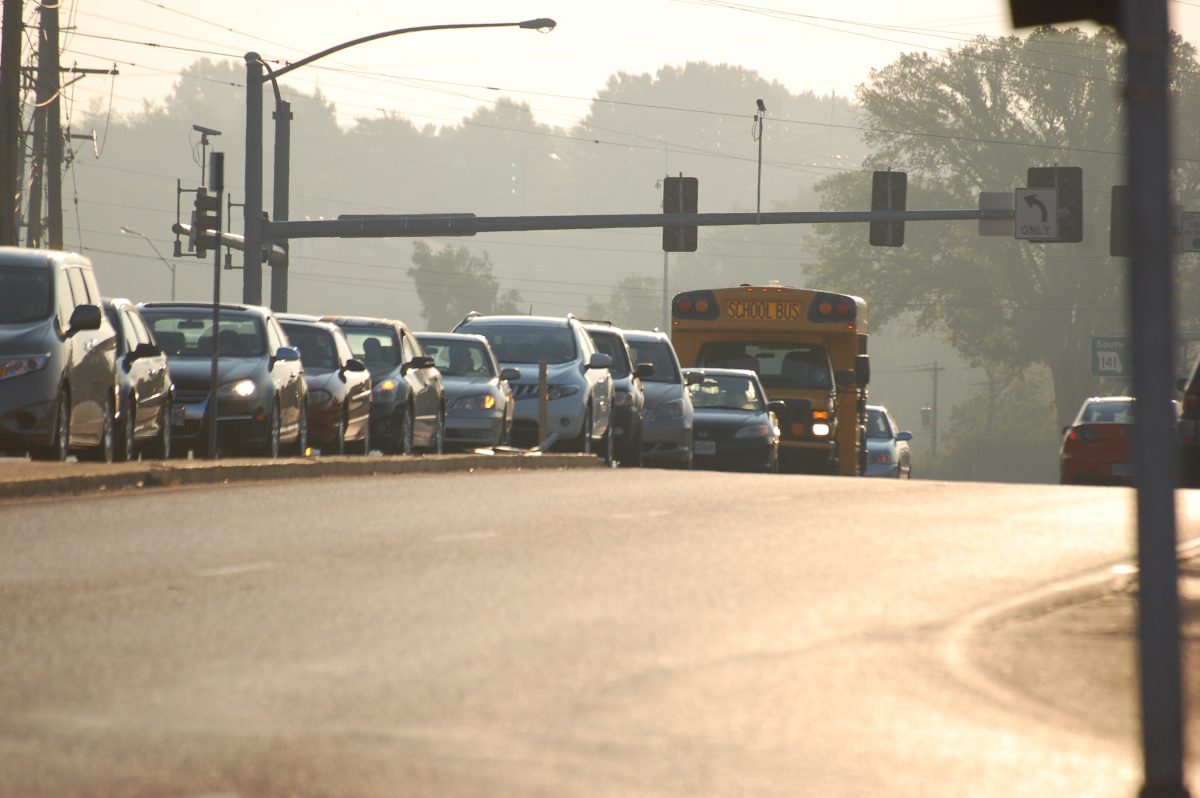 Cars and a Parkway Bus wait to turn left from Olive onto Woods Mill going South in order to get to Parkway Central for the first day of school.