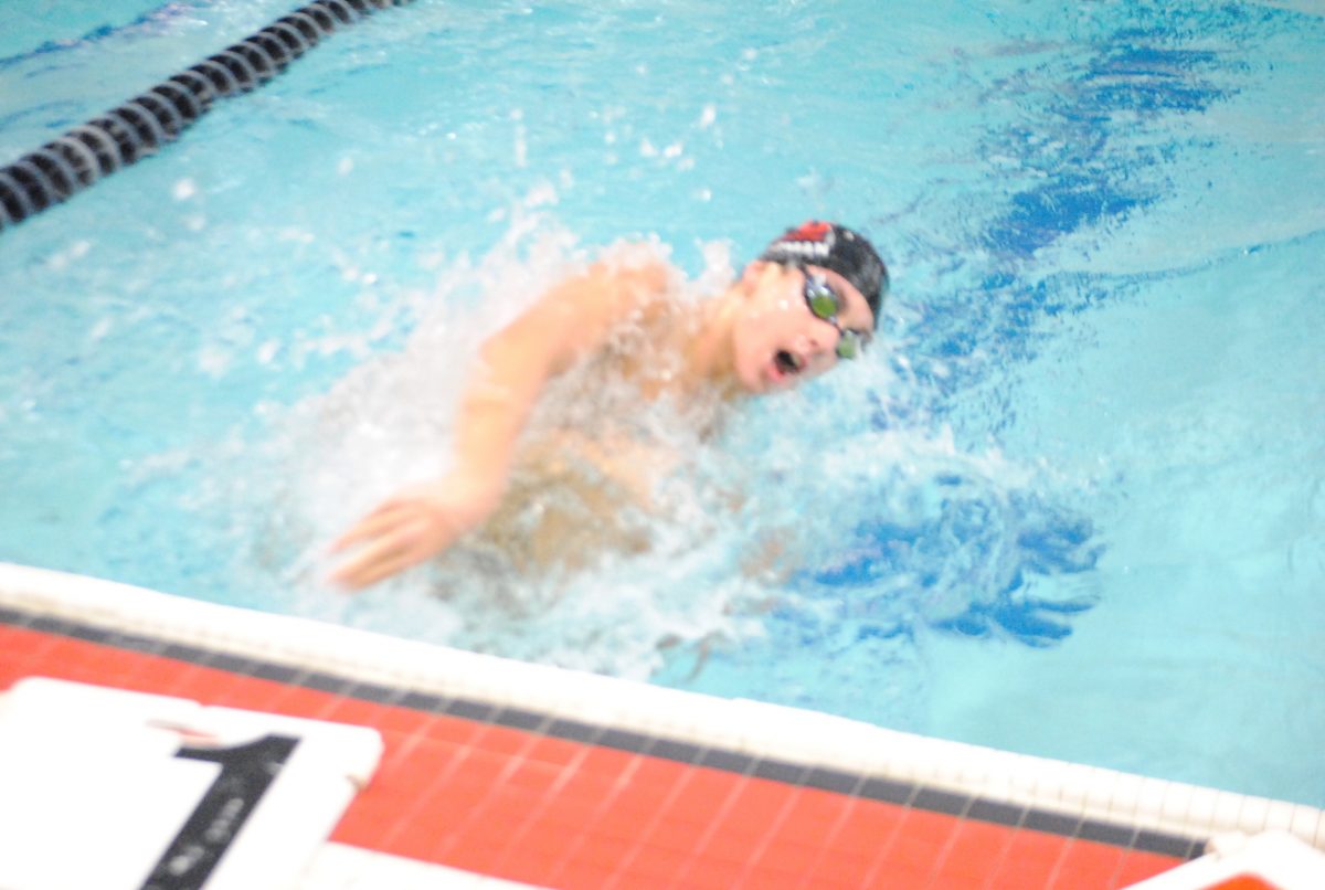 Senior captain Brandon Weissman turns for home in the 100 Yard Breaststroke. Weissman finished first in the event, with teammates Luke Oliver (9) and Matt Walter (11) finishing in fourth and fifth, respectively. Photo by Ms. Tara Stepanek.