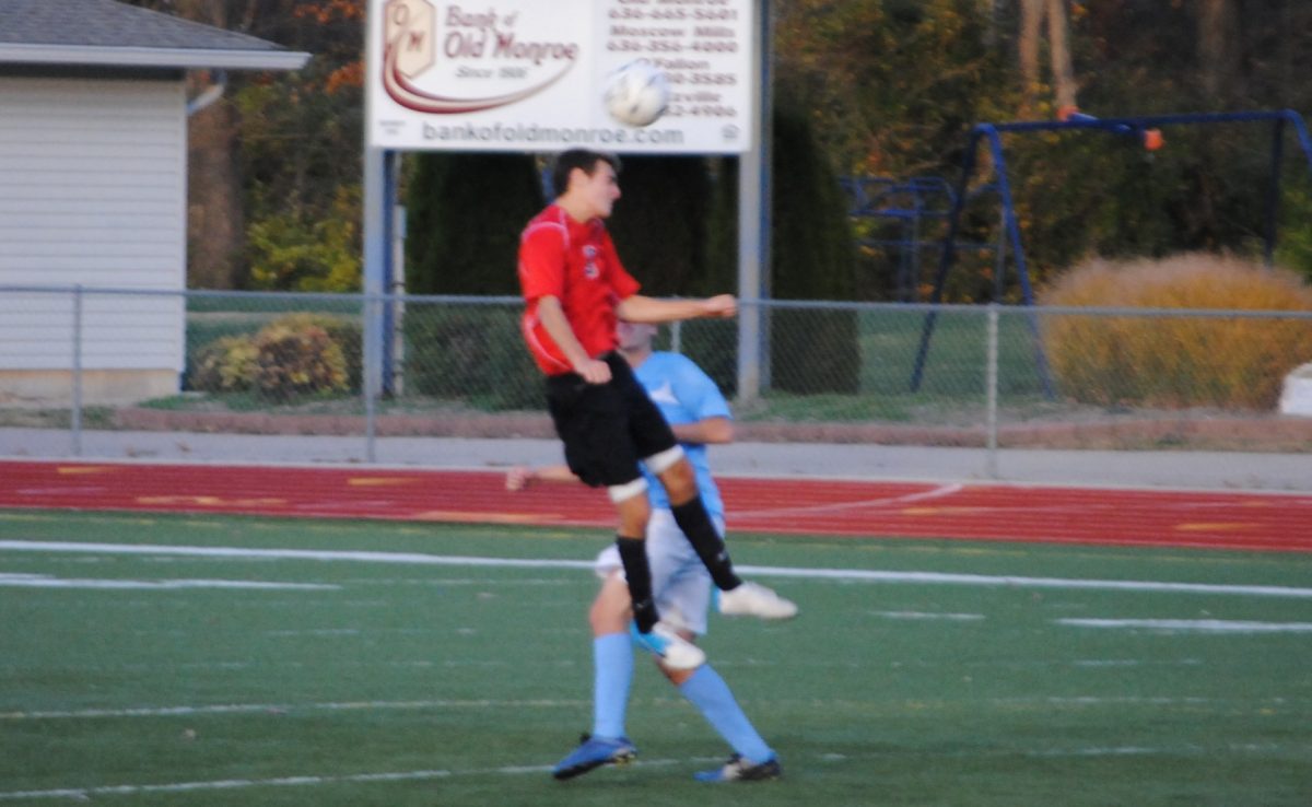 Senior Alex Mischel jumps for the ball in the game against St. Dominic on Saturday.  Photo by Ms. Stepanek