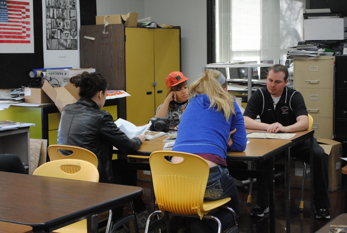 Mr. Brian Guilfoyle, art teacher, explains an assignment to a table of his Photography 1 and 2 students.