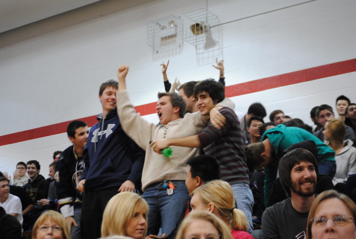 Juniors Patrick Cannon (left), Hayden Klepper (middle), and Jacob Zenk (right) celebrate a junior class win in the bean bag competition at the Winter Pep Assembly.  Photo by Matthew Walter