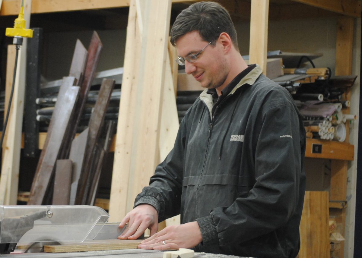 Mr. Matt Forbis slices a 2x4 in preparation for the spring show. Photo by Katie Richards.