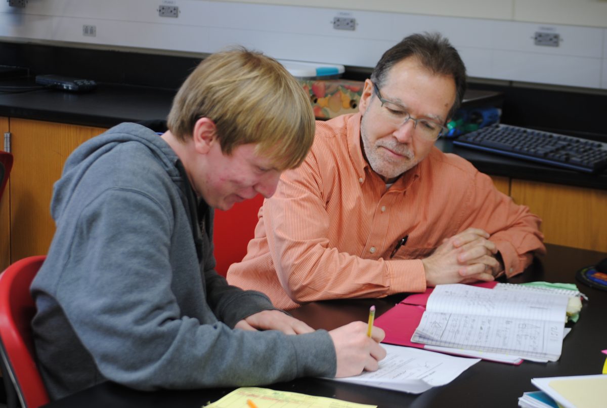 Jim Lewis helps out senior Ivan Miller with his physics work in Mrs. Jennifer Meyers classroom. Photo by Zach Prelutsky.