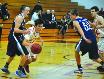 Junior Brendan Ecker dribbles toward the basket in the boys junior varsity win over St. Charles on Jan. 15. The boys went into overtime against the Pirates and were able to pull out a four-point win. Photo by Matthew Gibbs. 