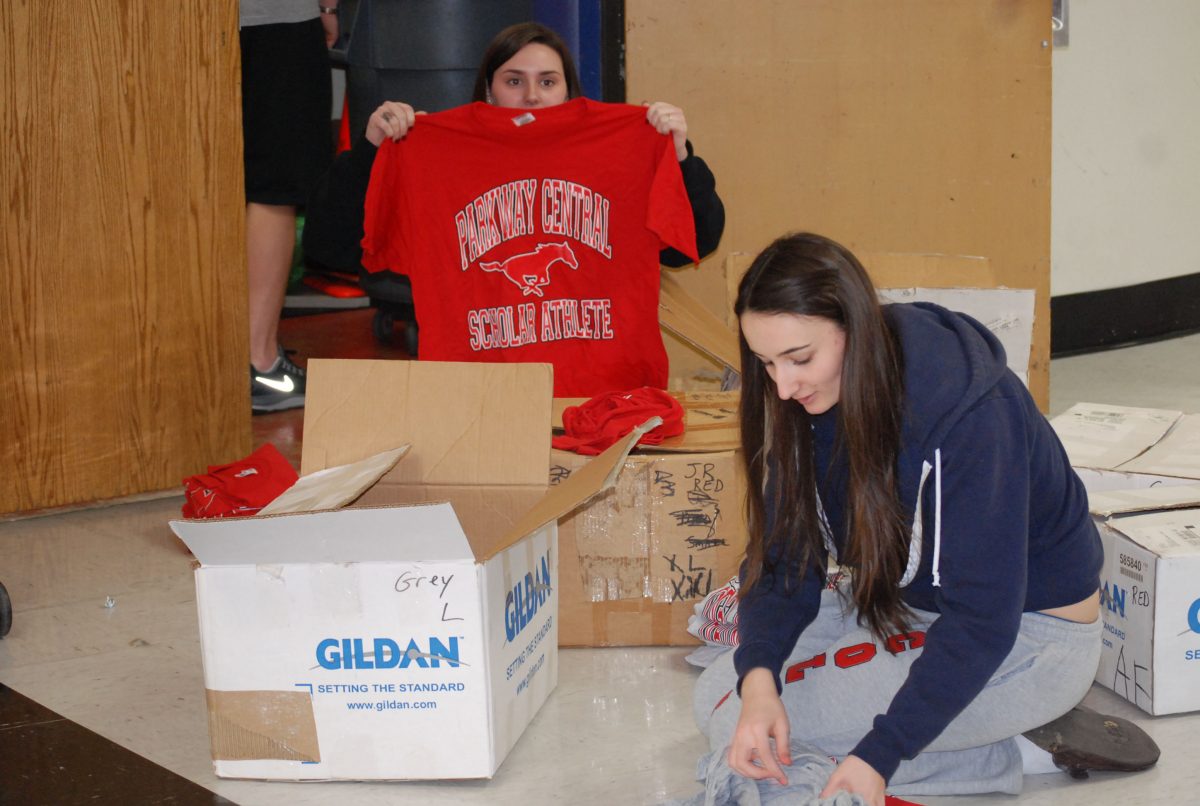 Seniors Katie Mestres and Stephanie Wunning sort PCH scholar-athlete shirts during office aid. Photo by Zach Prelutsky. 