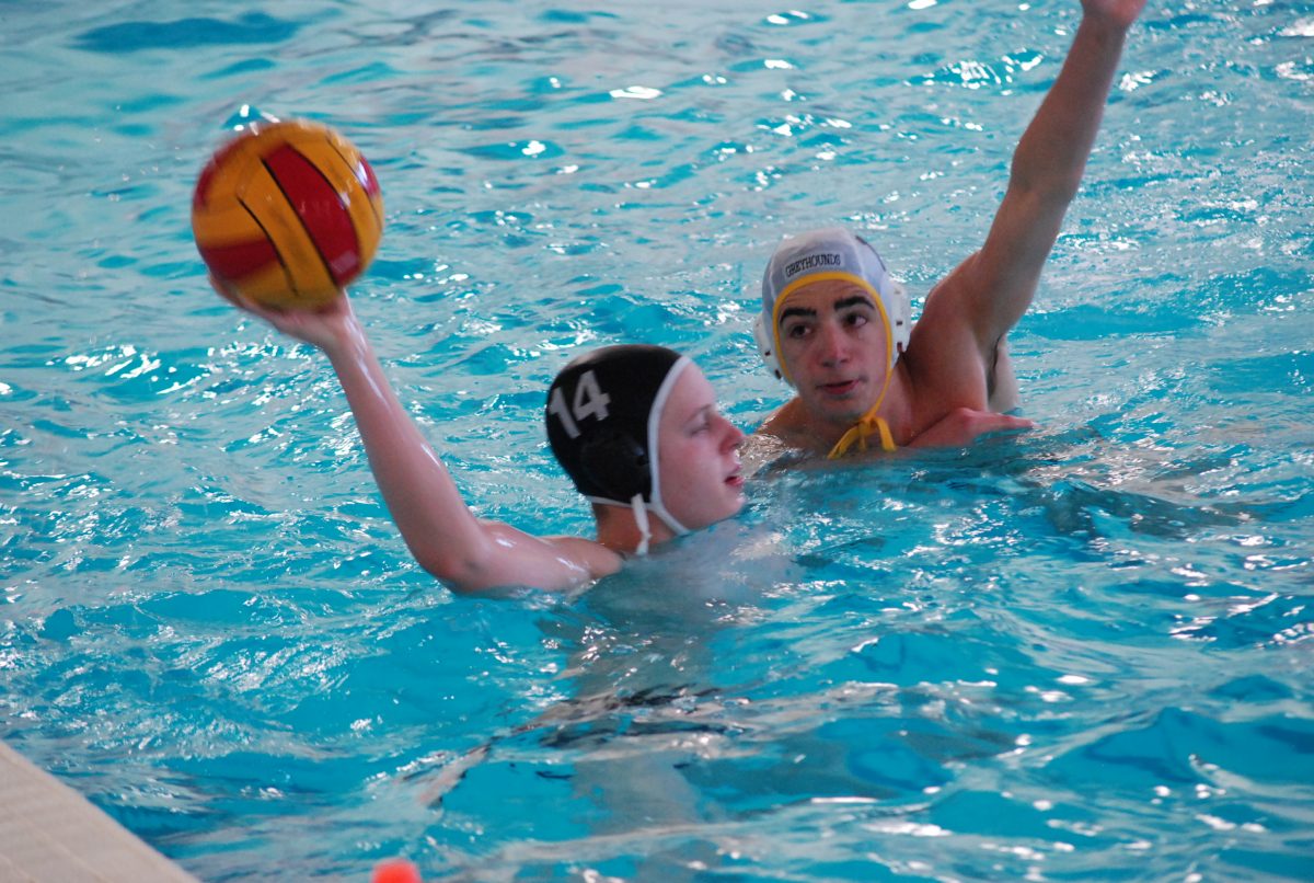 Sophomore Luke Oliver looks for an open teammate while a Clayton defender prepares to block the pass. The Colts varsity water polo team was defeated by a score of 15-5. Photo by: Tara Stepanek