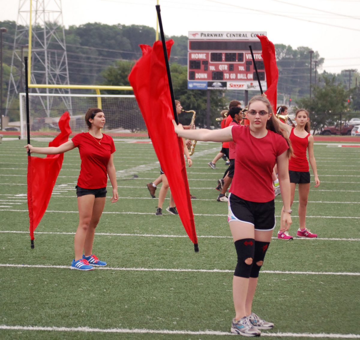 Freshman Zoe Miller performs with the color guard during Red and White Night. The color guard plans to make several changes to their show before the next band competition. Photo by Clare Conlisk.