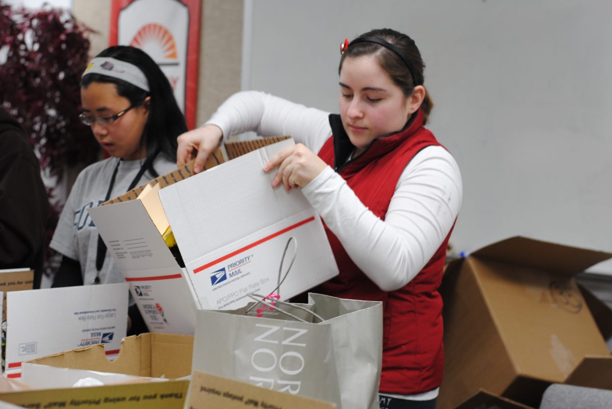 Senior Jill Kealing and freshman Lyana Chen work together to prepare soldier boxes. They brought extra goods like magazines and candy to make sure each box was properly stuffed. Photos by Emily Schenberg.