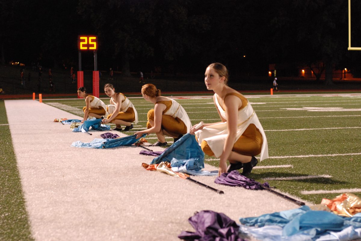 Senior Hannah Mosley (right) and the color guard prepare to start a new section of their routine at a half time game.