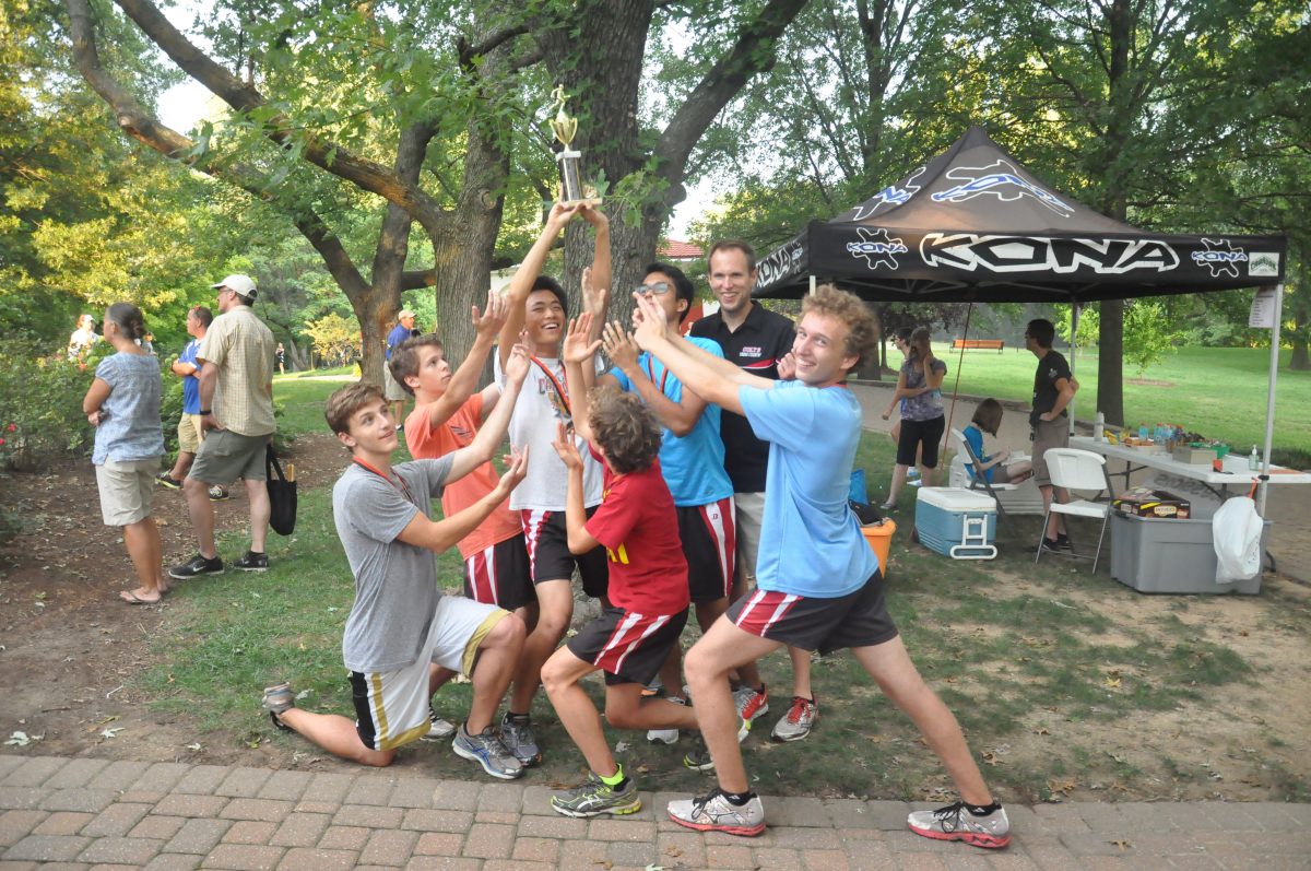 The varsity cross country team celebrates after winning their trophy at the Webster Warm-up on September 4.