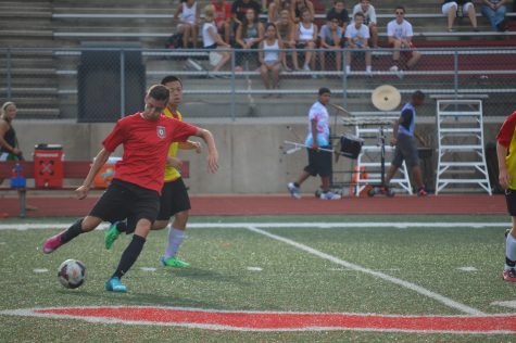 Senior Luca Vezin chips the ball down the field to try to set up an open teammate on Aug. 14 in the annual Red & White Night.  