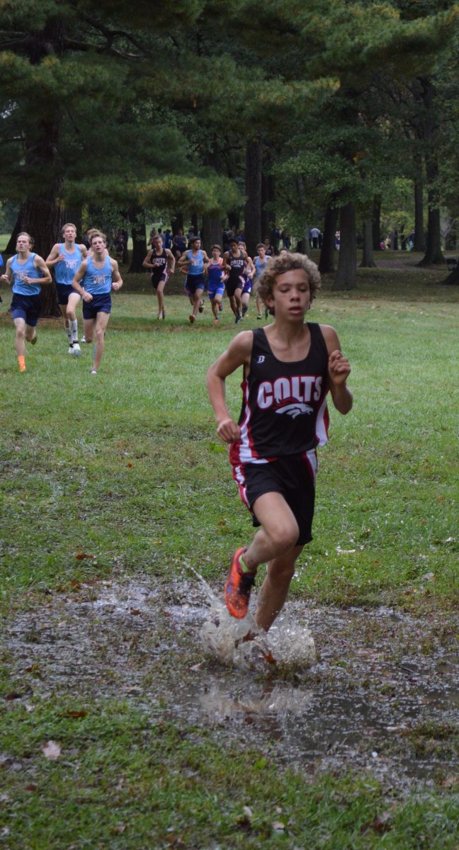 Splashing through the puddles on his way to earn first place at the conference meet, sophomore Charlie McIntyre helps the team earn 2nd place at the the meet which was held on Oct. 11 at Willmore Park.