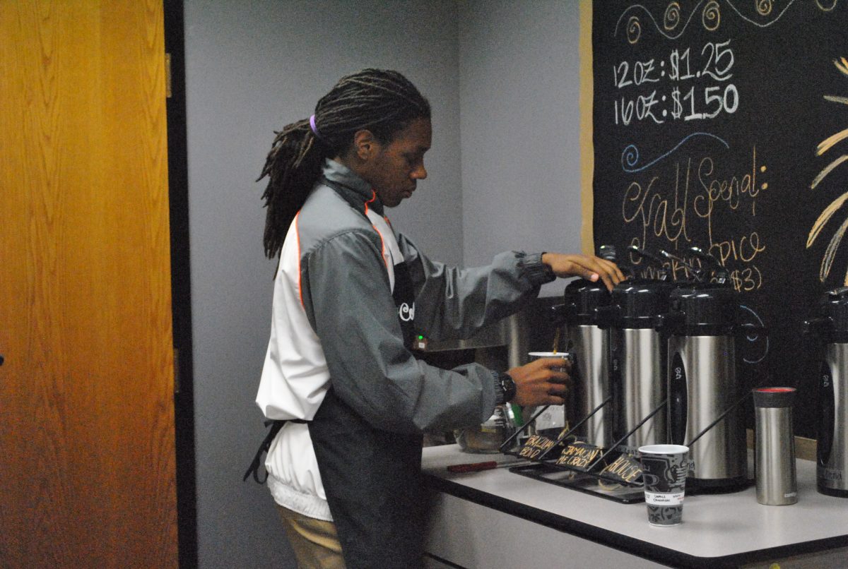Senior Joshua Herbert prepares a cup of coffee for a customer at the new coffee shop open in the business wing on Nov. 7. Photo by Ashley Wright.
