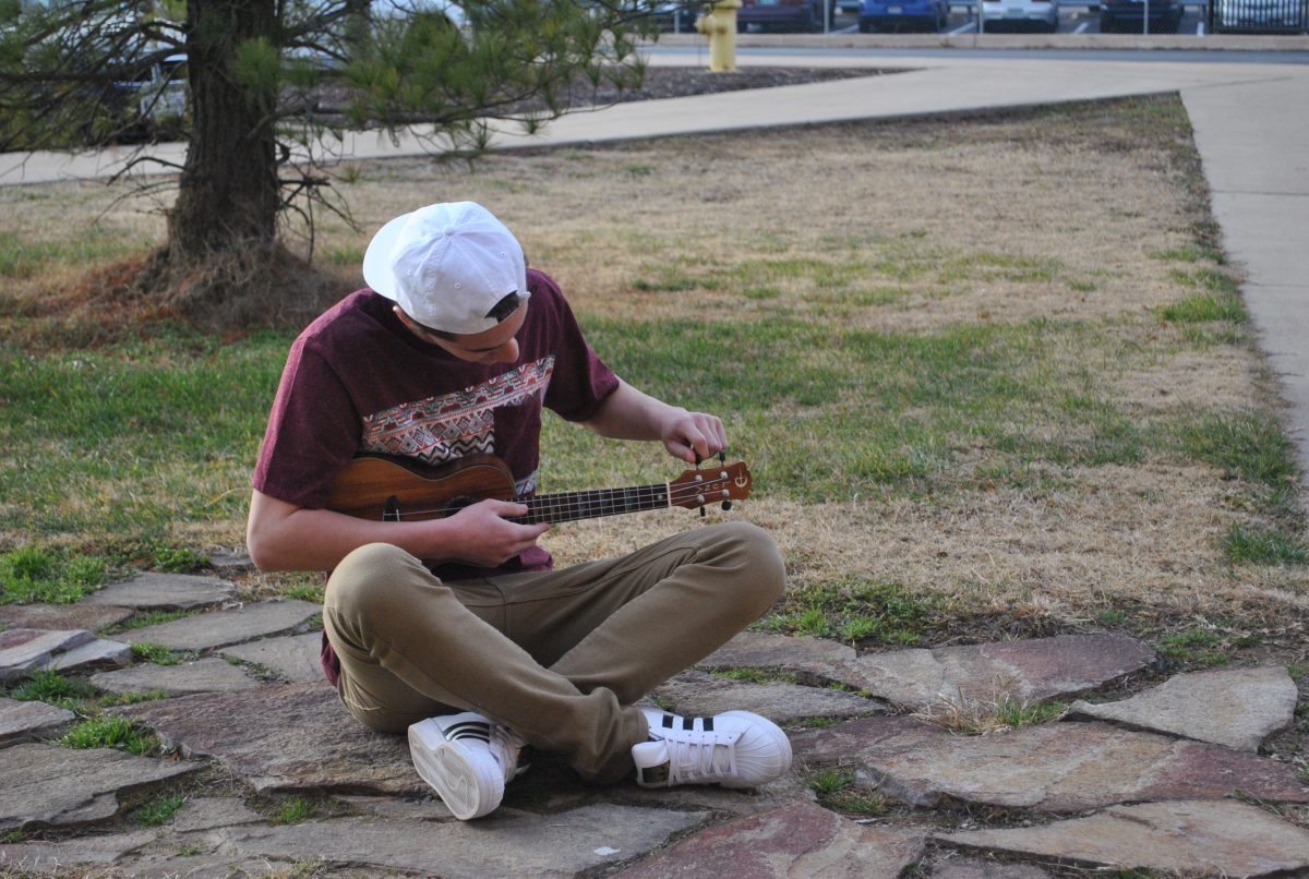 Junior Matthew Whay strums the ukulele during academic lab behind the music wing. “I hope to be able to spread the beautiful sound and good vibes of the ukulele throughout the halls of Parkway Central,” Whay said. Photo by Jeffrey Eidelman.