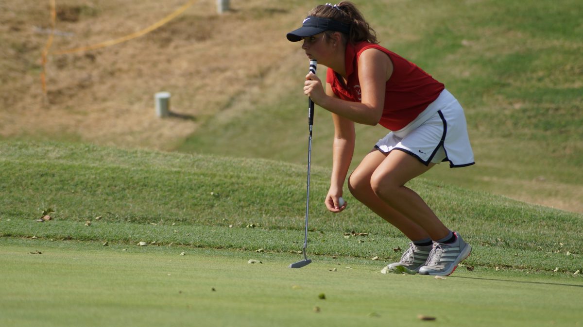 Senior Melanie Wilmert looks for the best angle to hit the ball on the green at the Four Seasons Country Club on Sept 7.  “My mental game has improved,” Wilmert said. “I have learned how to forget about a bad shot and just keep playing my own game.” This helped her recover from the bunker after hitting a few shots into the sand during State.
Photo by Noah Weidner