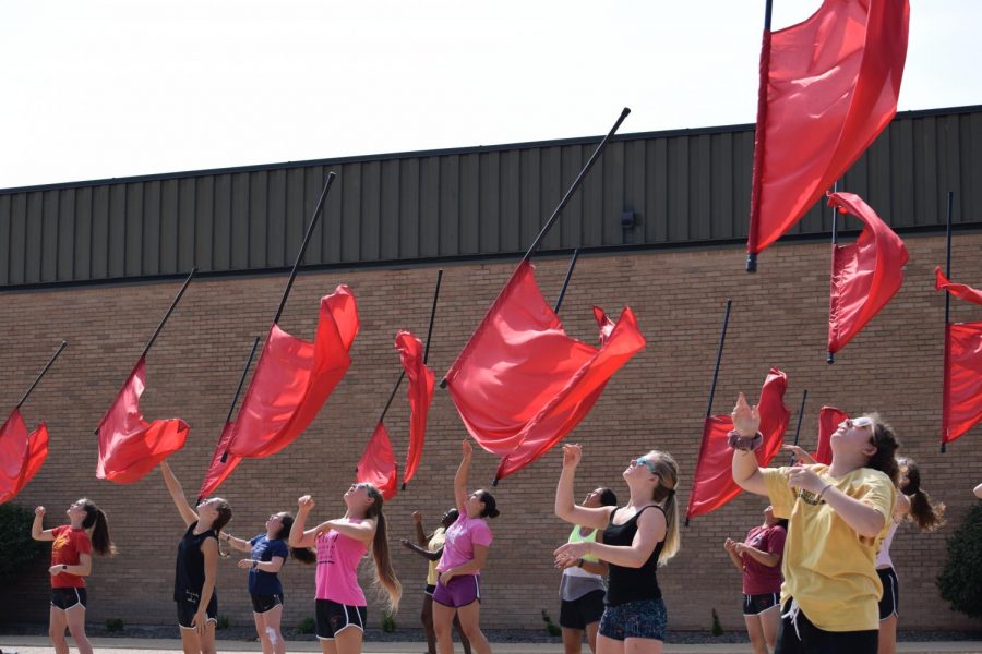 The color guard practices their tosses in anticipation of a competition.