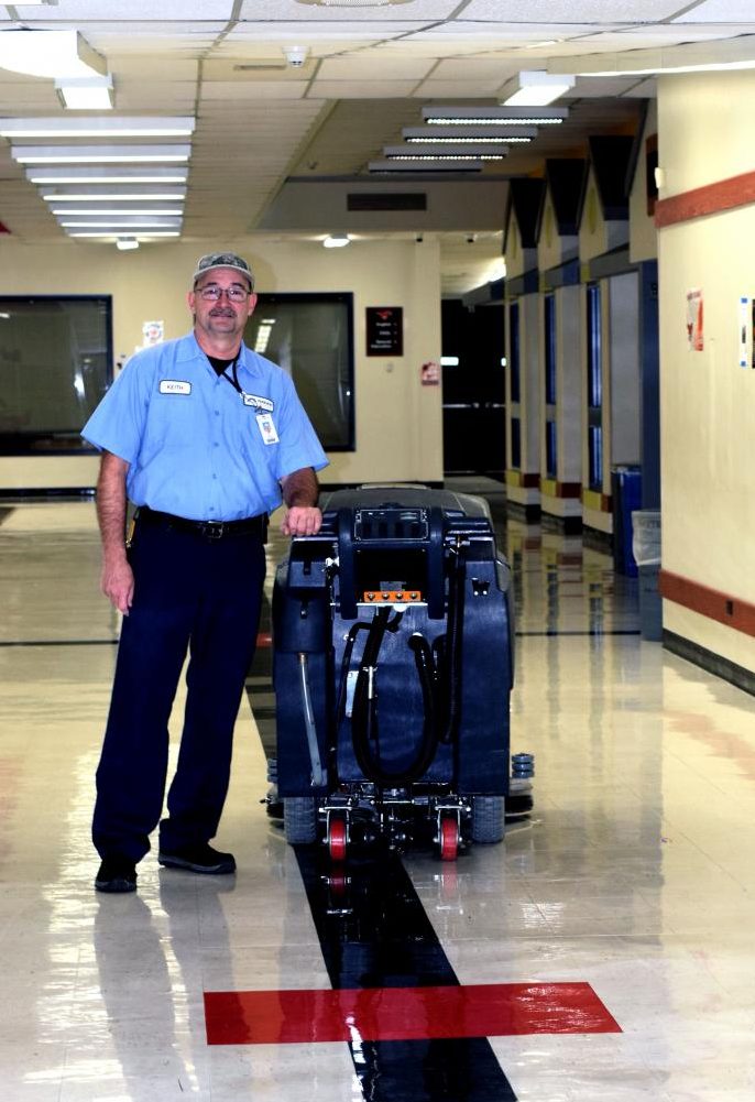 Parkway Central Custodian, Donald Keith Styles with a floor cleaner.