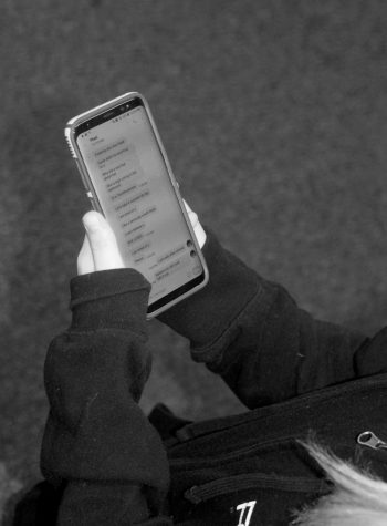 Student checks her phone for messages. Drama can be started through texting. Photo by Ryan Pham