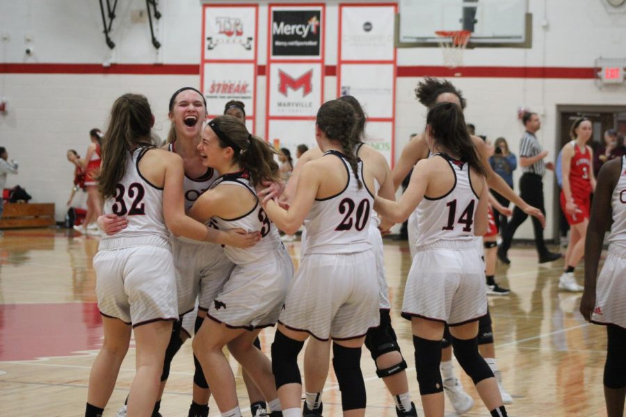 The girls varsity basketball team celebrates their district championship win on March 1, 2019 against Kirkwood. 