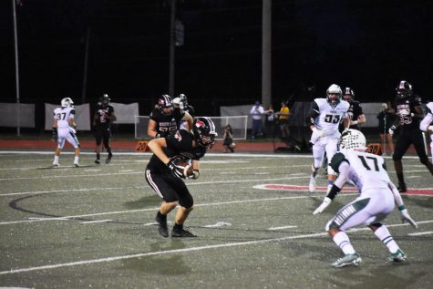 Cam Roberts runs with the ball after making a reception in a game against Fort Zumwalt North on 9.13. “I consider wide receiver my primary position even though there’s only one punter on the field at a time, but there’s always multiple wide receivers on the field,” Roberts said. Photo by Christine Stricker.