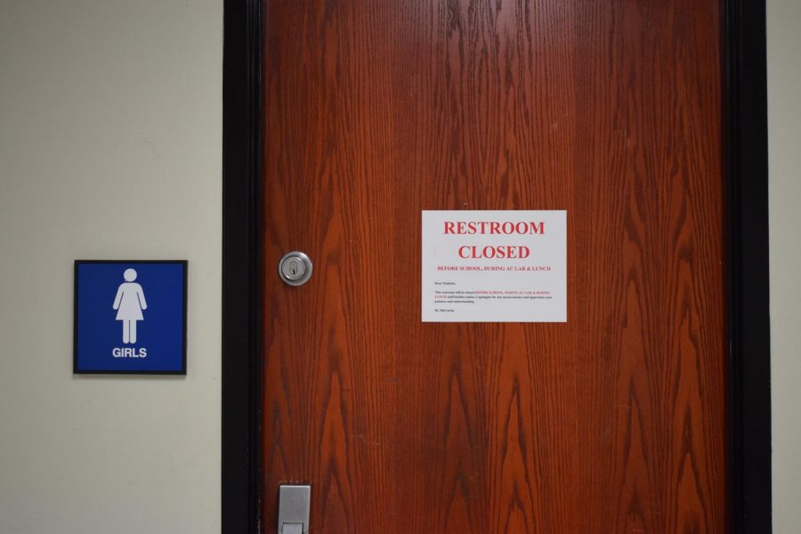 Bathroom door covered with restricted sign. 