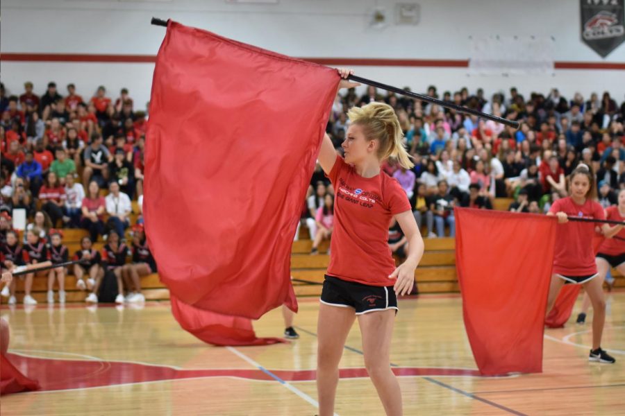 Senior Tristan Duggan spins her flag at the homecoming pep rally. Photo by Christine Stricker