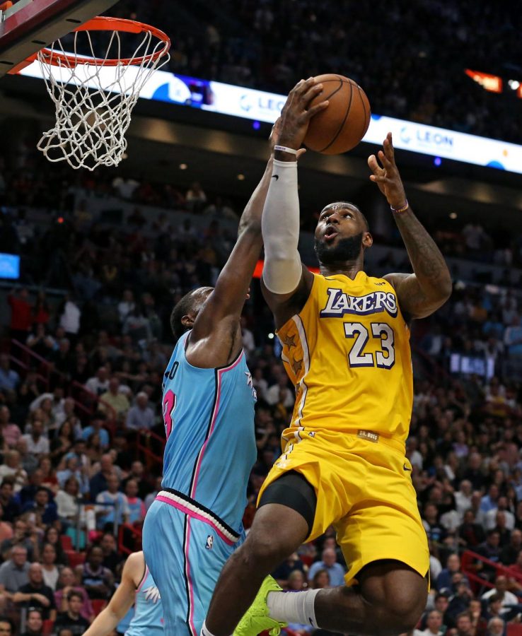 The Los Angeles Lakers' LeBron James (23) goes to the basket against the Miami Heat's Bam Adebayo in the fourth quarter at the AmericanAirlines Arena in Miami on Friday, Dec. 13, 2019. The Lakers won, 113-110. (David Santiago/Miami Herald/TNS)