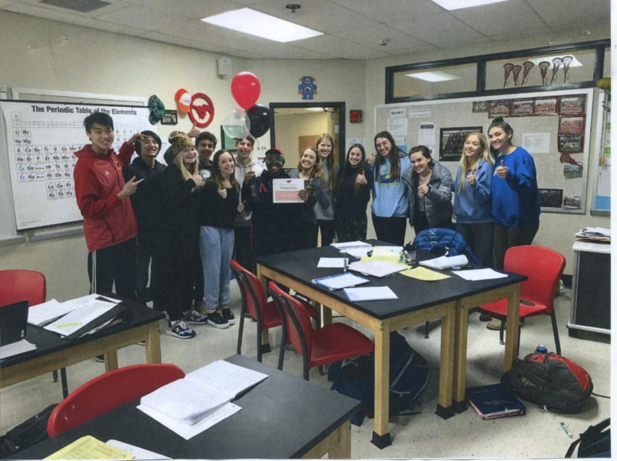 Sophomore Peyton Silas receives his water bottle and award, posing for a picture with the students in Sarah Hale’s leadership class. Photo courtesy of Student Council.