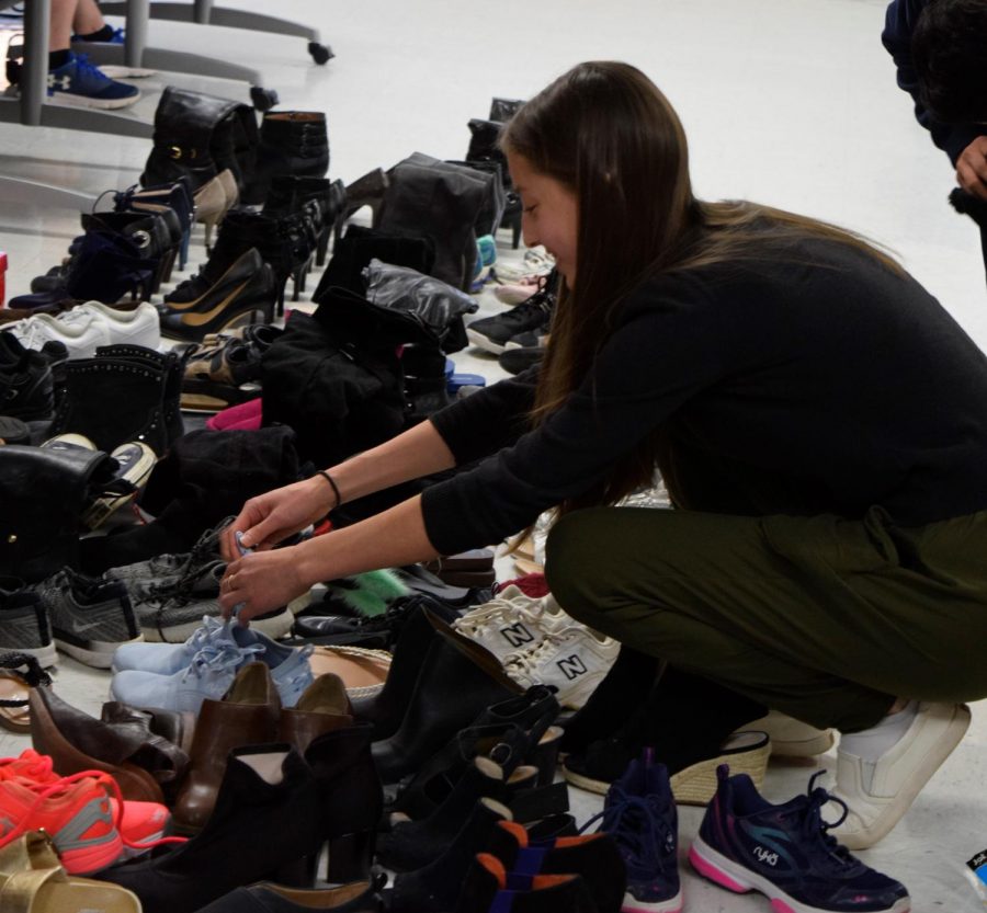 Senior Maria Vabson going through shoe donations collected by the senior class during Month of Giving. Month of Giving is held during November and it is when all the different grade levels compete to collect donations for their respective charities. 