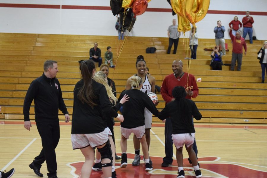 The+girls+basketball+team+rushes+the+floor+to+congratulate+senior+Jayla+Kelley+on+her+1%2C000+point+and+1%2C000+rebound+accomplishments+on+Feb.+18+at+the+PCH+gym.+