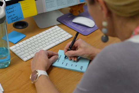 Journalism teacher Christine Stricker writing an Ac Lab pass for a student. A common criticism of Ac Lab is the pass system. Some teachers and students believe that the pass system is overly complicated and hinders students’ ability to get help. Photo by Trey Williams.