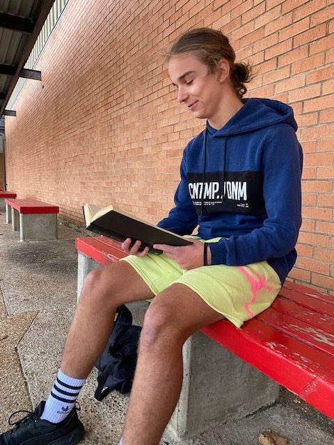 Senior Wiktor Waligora waits for soccer practice while reading a book on Nov. 17. 
