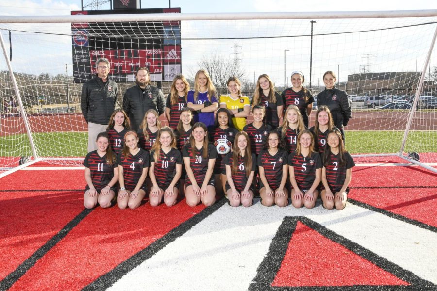 Entire girls’ varsity soccer team, including coaches, take team pictures.

