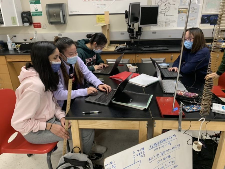 Science Olympiad members Sonali Paranjothi, Karen Lee, Emily Huang, and Emily Wang (11) work together in a science classroom. 