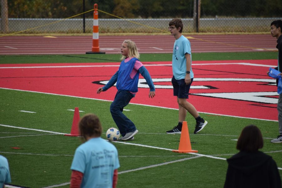 Special Olympics plays soccer on the field.