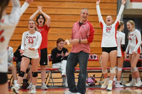 Alyssa Ahrens, Tom Schaefer, and Shelby Devlin cheer on the Colts volleyball team. Photo by Christine Stricker.