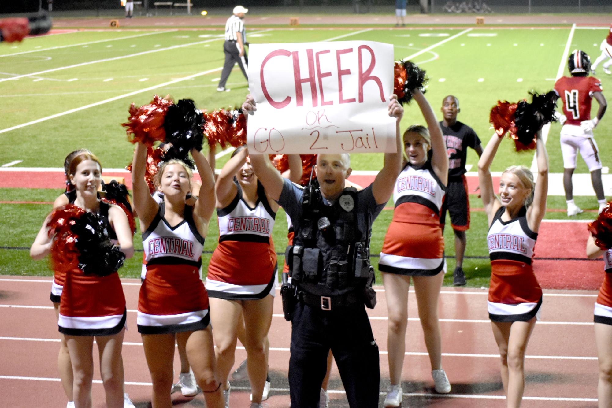 School resource officer Kaatmann holds up a sign to get the crowd going during the home football opener on Sept. 9. This upcoming week brings with spirit days, pep rallies and class games.