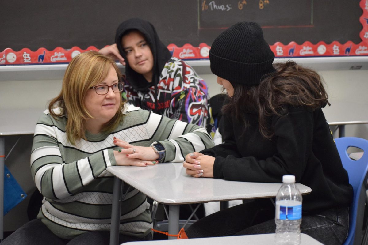 EL Specialist and ESOL Department Head Stacy Henry talks with Lizeth Rozo Barroso (12) during a sheltered EL Government class. 