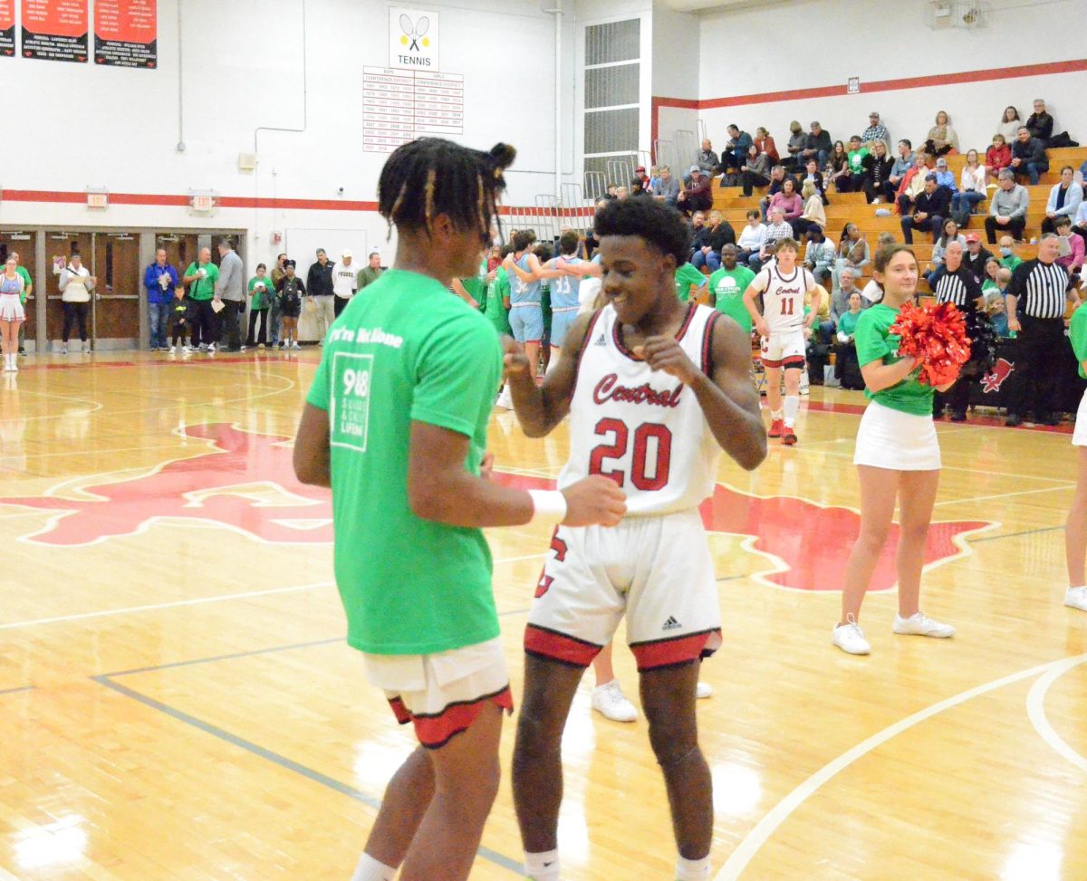 Aamir Banks and Dillion Harris doing a handshake during the starting line up announcement at the Talk 4 Tyler game on Nov. 28 at Parkway Central.
