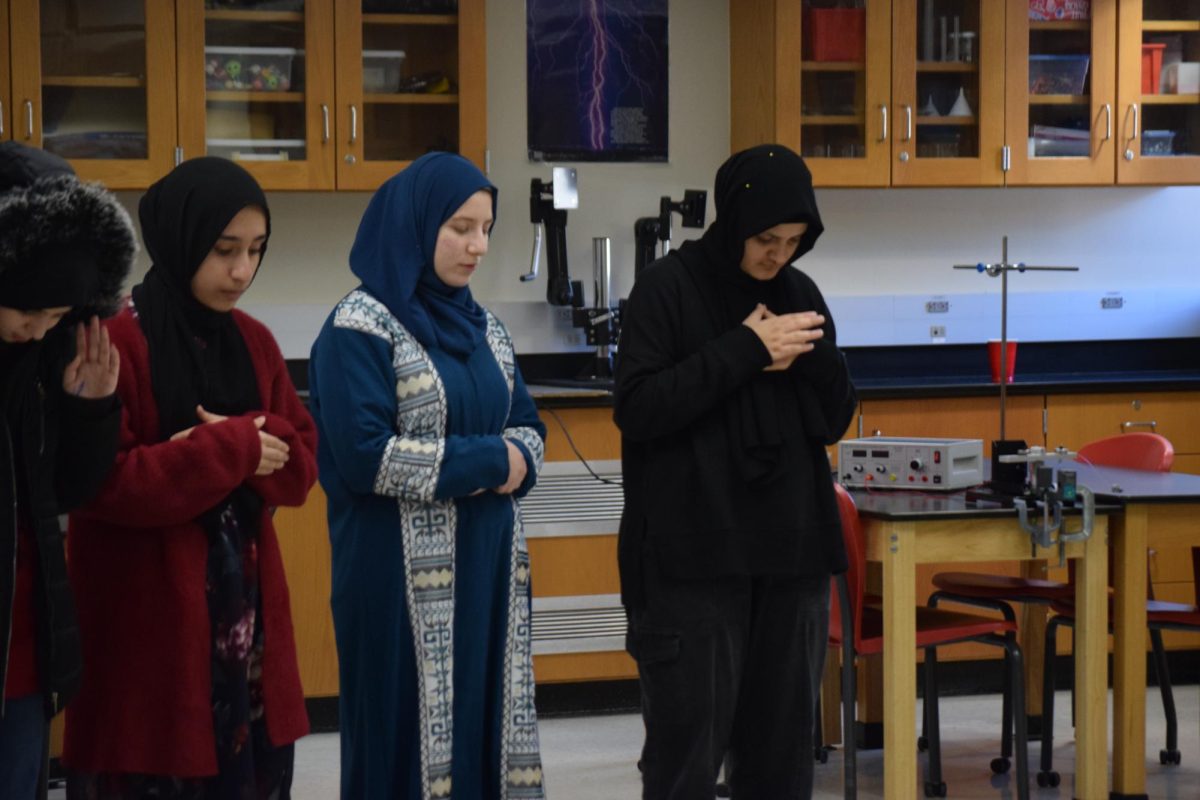 Asra Khalji (10), Bassma Albitmouni (11) and Manahil Rahimi (11) praying in science teacher Ryan King’s room. 