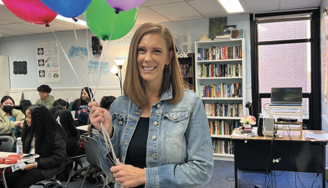 Sarah Burgess poses with balloons in her classroom the day she learned that she won Teacher of the Year.