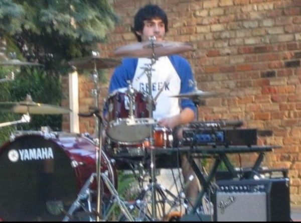Peter Papulis plays the drums during a backyard concert.