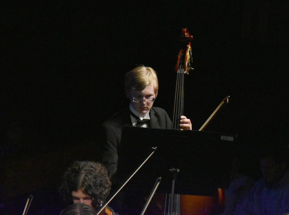 Sophomore Ronan Schmidt plays the bass at the orchestra concert on Sept. 24. The orchestra is kicking off the season with a folk music concert. 