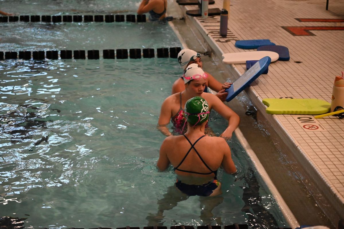 Reese Anderson (11), Gabriellle Salmans (10), and Gianna Pearson (9) pause on the wall to discuss their workout on Jan 22. 