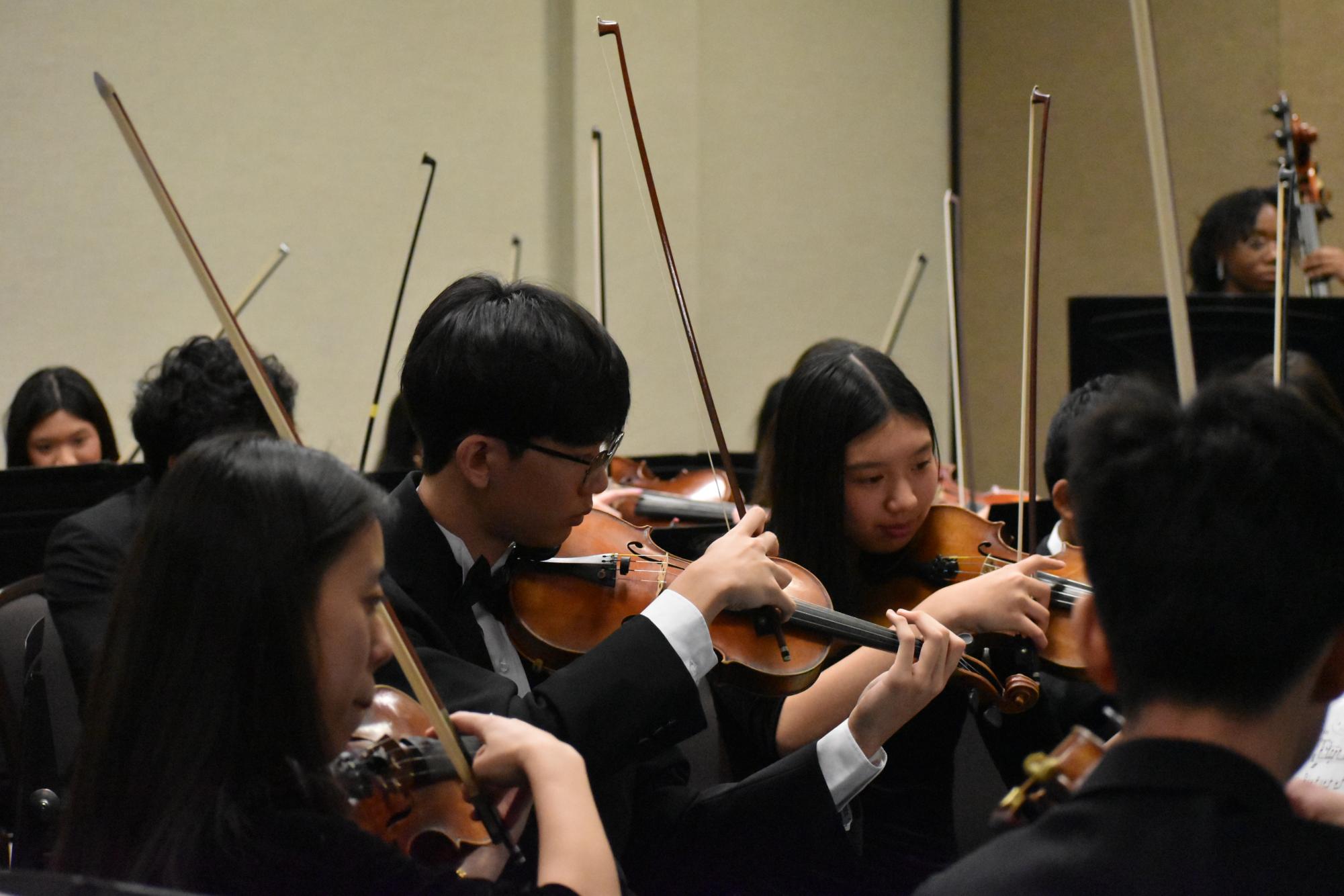 Grace Li (12), Aiden Moon (11) and Henna Lee (10) play violins on Jan. 30 during MMEA soundcheck.