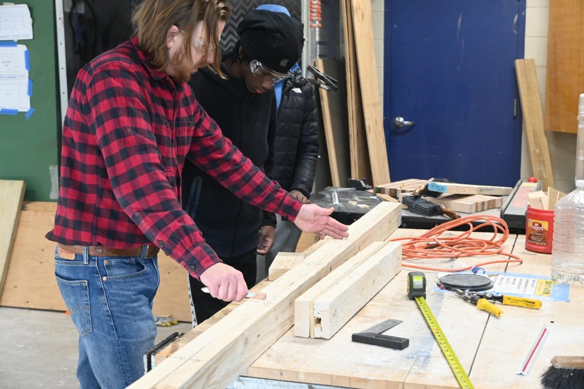 Brandon Franck works with Fharoah Harmon (9) in Construction Technology on Feb. 13