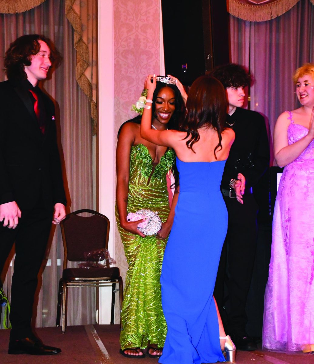 Senior Ty’Riana Cartwright smiles big as senior Sydney Segal places her crown on her head. 