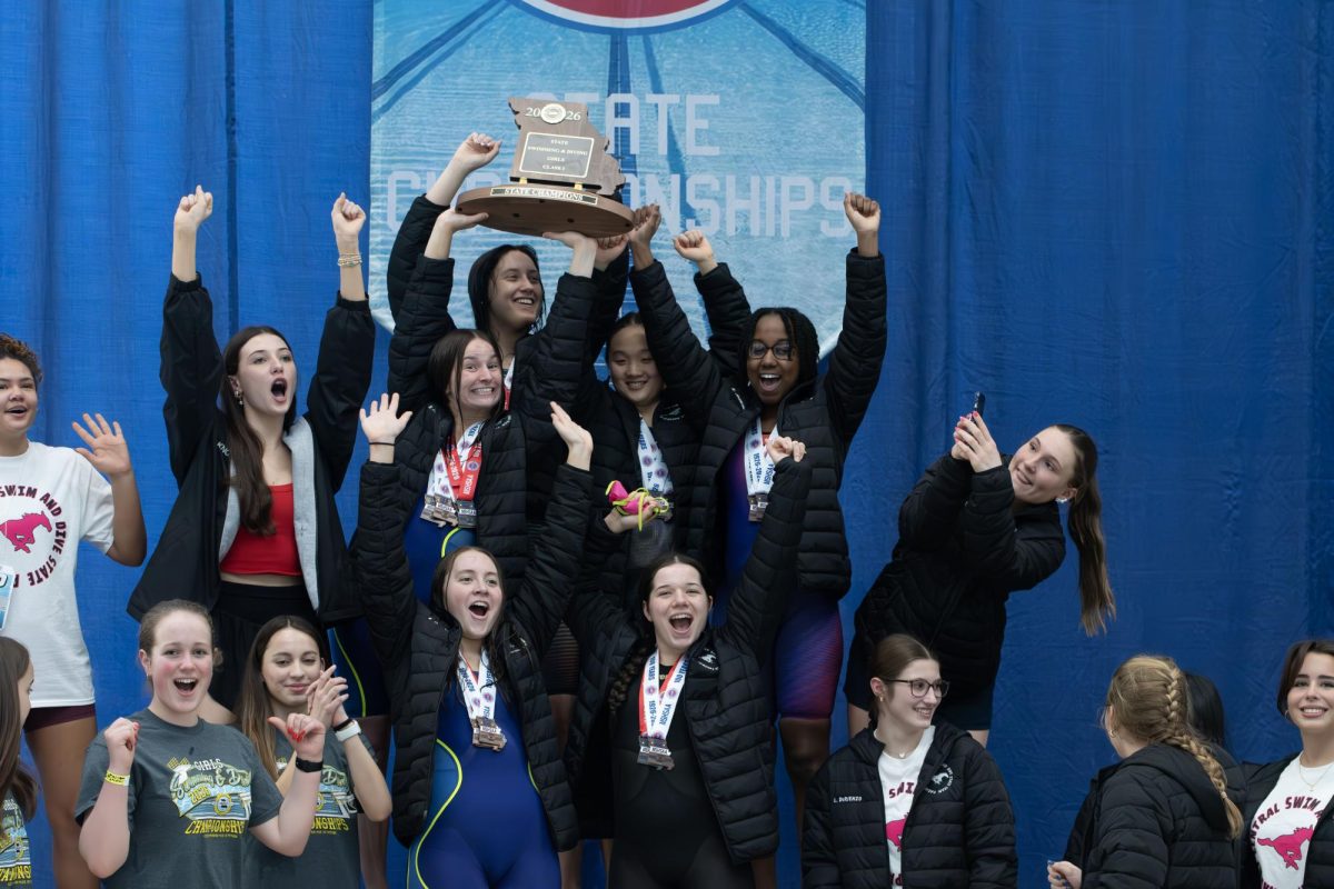 The girls swim and dive team celebrates  with their championship trophy on Feb. 20. 